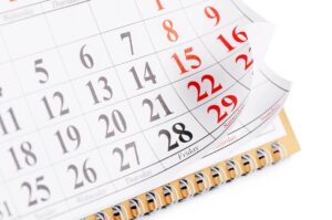 Calendar with bottom right part of page turning against a white background