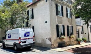 USPS delivery van parked in front of a building