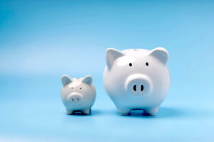 small piggy bank next to a large piggy bank on a light blue background